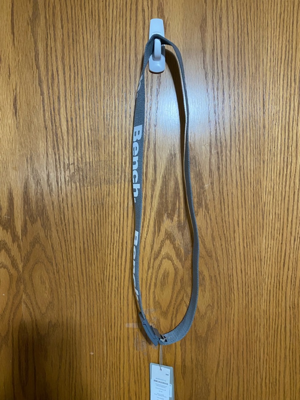 Grey bench belt with bottle opener on belt buckle